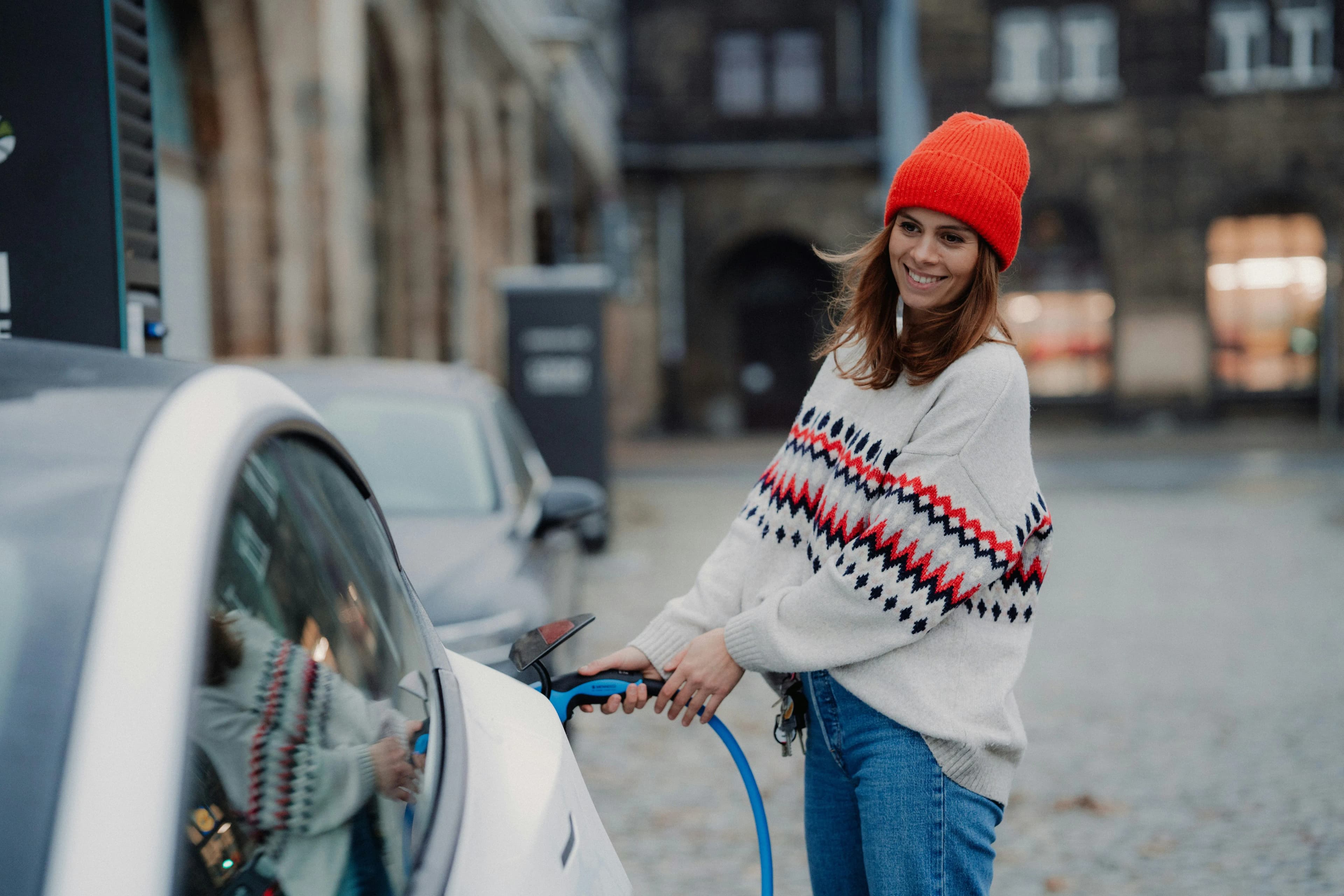 femme rechargeant sa voiture électrique