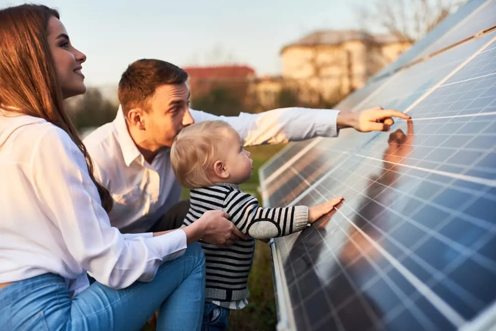 une famille devant des panneaux solaire